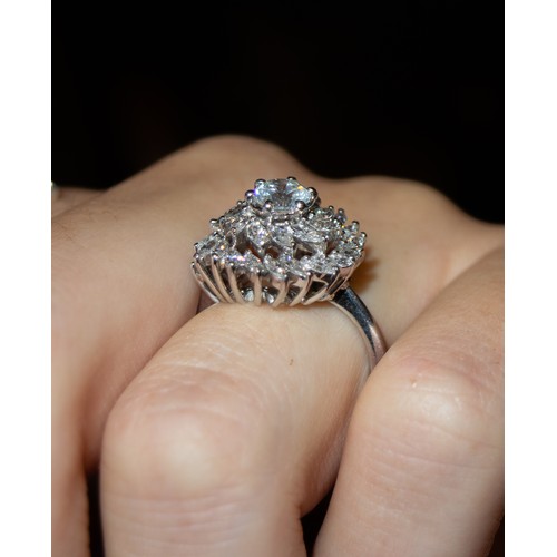 32 - BritishCirca 1990A diamond cluster ring, set to the centre with a single brilliant cut diamond. Appr... 