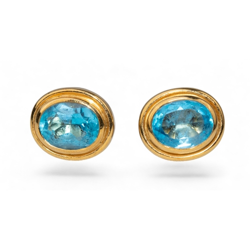 1 - ContemporaryA pair of blue topaz and 18 carat yellow gold ear studsThe oval mixed blue topaz collet ... 