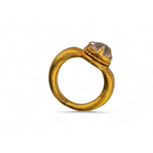 10 - AncientA high carat gold and rock crystal ring.The heavy tapered yellow gold hoop with a rock crysta... 