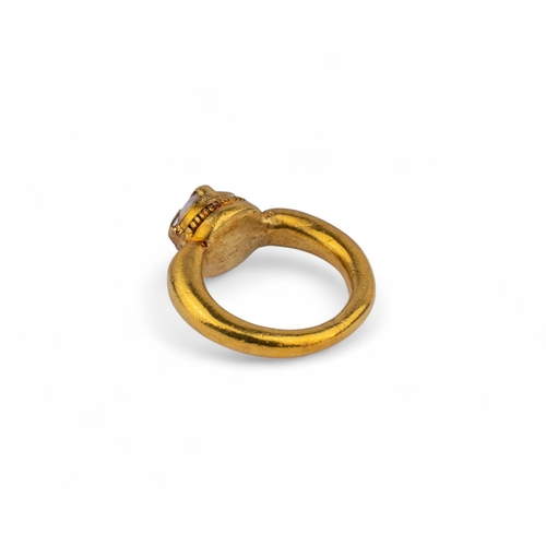 10 - AncientA high carat gold and rock crystal ring.The heavy tapered yellow gold hoop with a rock crysta... 