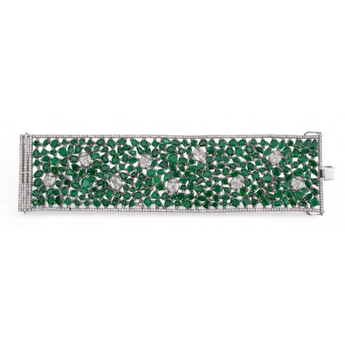 96 - Continental, Circa 1990A highly flexible material-like emerald and diamond bracelet.The wide bracele... 