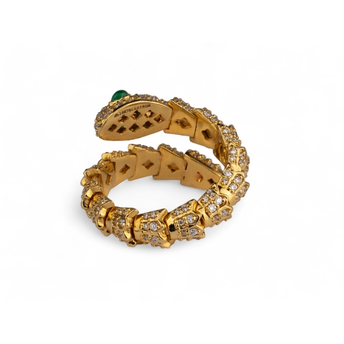 102 - Continental, ContemporaryA diamond and 18 carat yellow gold snake ring.Set with cabochon emerald eye... 