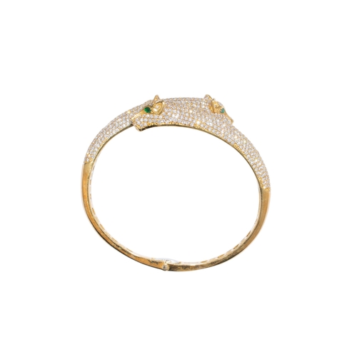 113 - Continental, ContemporaryA fine quality diamond and emerald panther bangle.The two overlapping panth... 