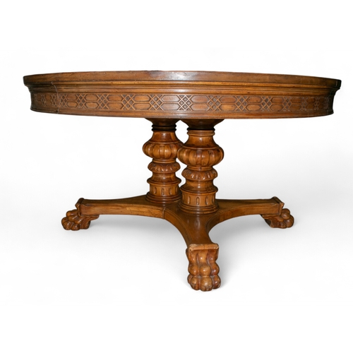 260 - English 19th CenturyA walnut (?) round dining table, with claw feet and mounted upon twin mounted pe... 