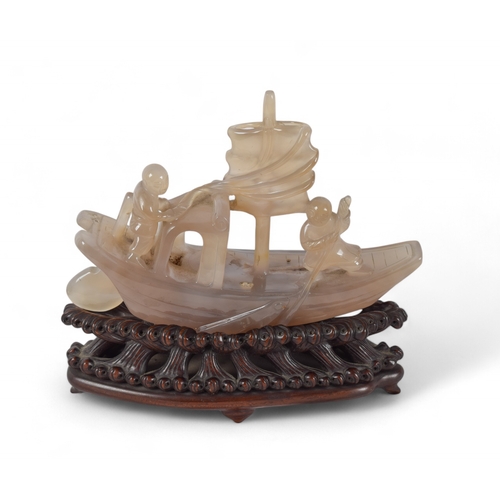 363 - Chinese, c. 1920A chalcedony model of a boat on an intricately carved honglu standTogether with a Ch... 