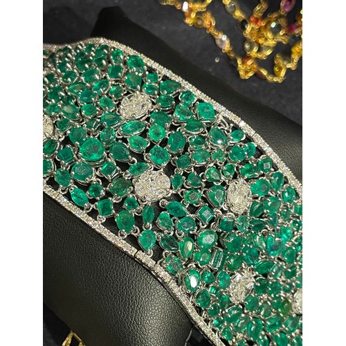 96 - Continental, Circa 1990A highly flexible material-like emerald and diamond bracelet.The wide bracele... 