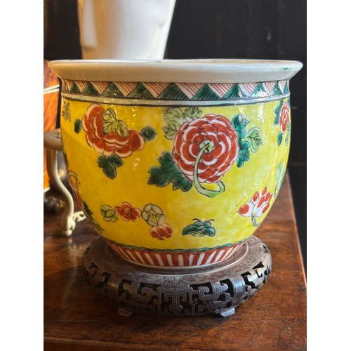 374 - Chinese20th centuryA small famille jaune ceramic pot on a pierced and carved wooden standProperty of... 