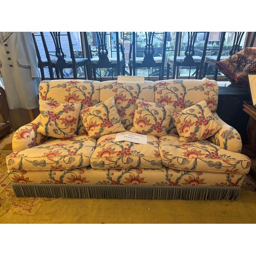 173 - A modern three-seater sofa upholstered in floral chintz with blue tassels Formerly in 73 Chester Squ... 