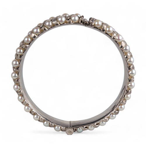 109 - Indian, circa 1960sA cultured pearl and silver coloured metal bangle