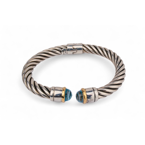 34 - ContemporaryA group of three silver twist gold and gem set bangles. The terminals set with topaz, ci... 