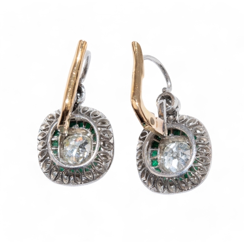 68 - EdwardianA pair of diamond and emerald cluster ear pendants, each centrally set with a cushion shape... 