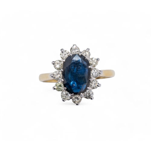 73 - Circa 1980sA sapphire and diamond cluster ring. The central oval shaped sapphire weighing approx. 3 ... 