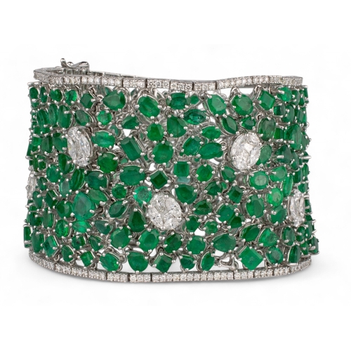 80 - Continental, Circa 1990A highly flexible material-like emerald and diamond bracelet.The wide bracele... 