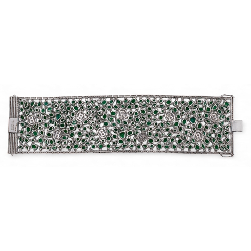 80 - Continental, Circa 1990A highly flexible material-like emerald and diamond bracelet.The wide bracele... 