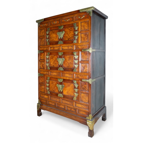 263 - Korean, AntiqueA tall three-tier cabinet with inset wood panels and brass butterfly handles and deco... 