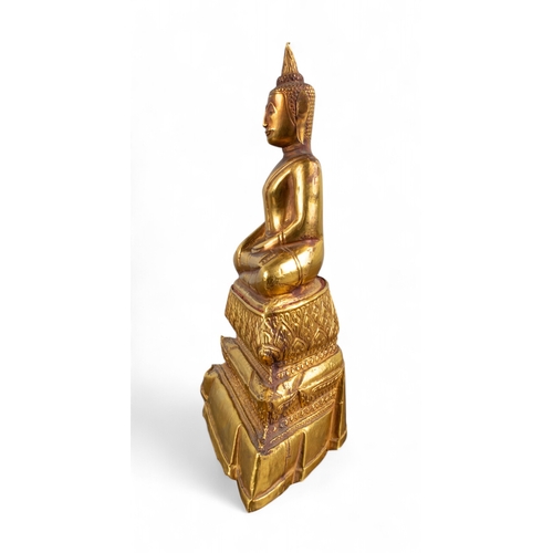 544 - Thai, 19th century (?)An elegant beaten gold and wood carved seated Buddha. The wood covered in a hi... 