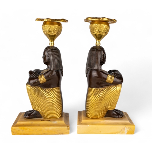 656 - French, circa 1800A pair of Egyptian Revival bronze and ormolu candlesticks in the form of seated fi... 