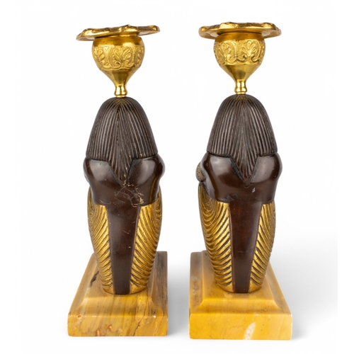 656 - French, circa 1800A pair of Egyptian Revival bronze and ormolu candlesticks in the form of seated fi... 