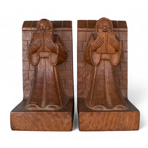 676 - A pair of Robert 'Mouseman' Thompson oak bookends carved as monks reading whilst leaning against wal... 