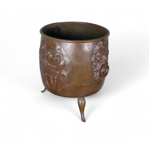 679 - A large bronze cauldron with neoclassical face decorations and three hoof feetProperty of ... 