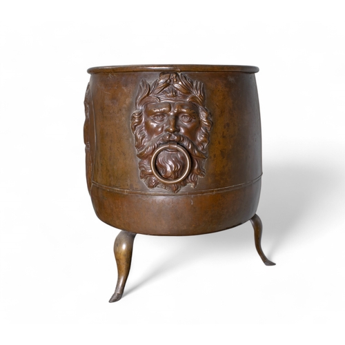 679 - A large bronze cauldron with neoclassical face decorations and three hoof feetProperty of ... 