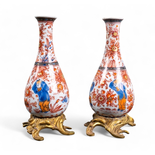 726 - Chinese, 18th centuryA pair of blue and white vases on giltmetal bases with later red decorationProp... 