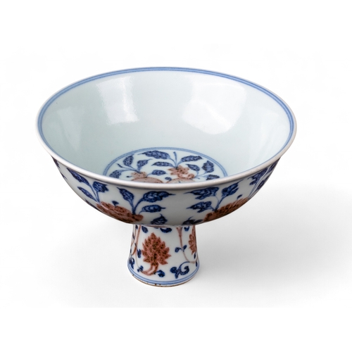 731 - Chinese, 19th centuryA Ming style underglaze blue and red stem bowl. The interior painted with peach... 