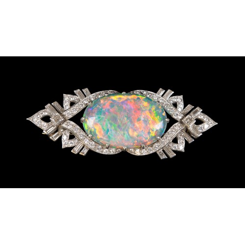 203A - A large Art Deco black opal and diamond brooch. The oval shaped black opal displaying a fine play of... 