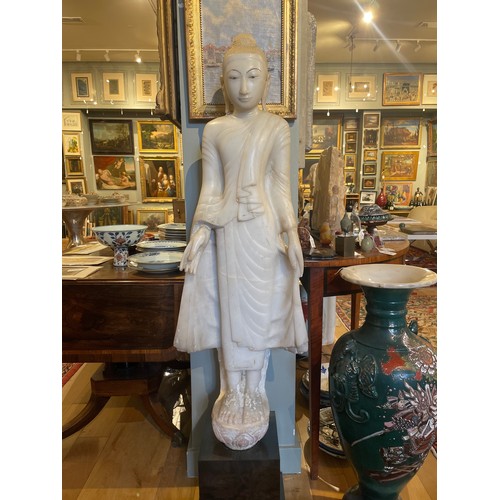 541 - Thai, 19th centuryA large carved painted and gilded white marble standing Buddha on a Lotus flower.D... 