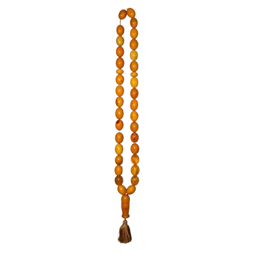 101 - An important and enormous butterscotch amber and amber prayer bead necklaceComprising of 36 large be... 