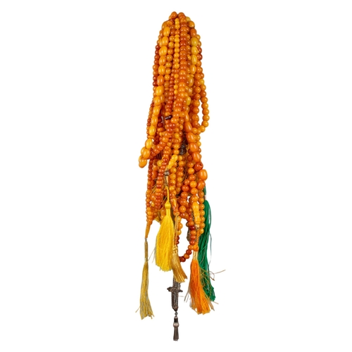 104 - A group of fourteen butterscotch amber and amber prayer bead necklaces. Some with gold and gilt meta... 