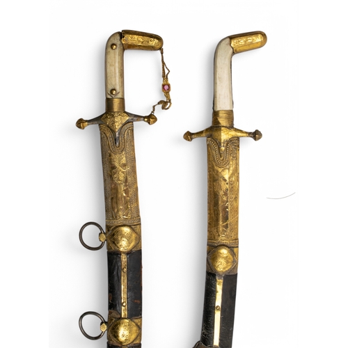 126 - 19th centuryTwo presentational Omani high carat gold clad leather swords, with bone handles.(Acid te... 