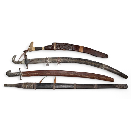 131 - AntiqueA group of four swordsTo include three Eastern silver mounted swords and a wood, leather and ... 