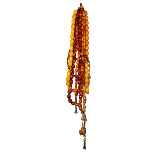 73 - Two butterscotch amber prayer bead necklaces together and three other prayer necklaces. Some with go... 