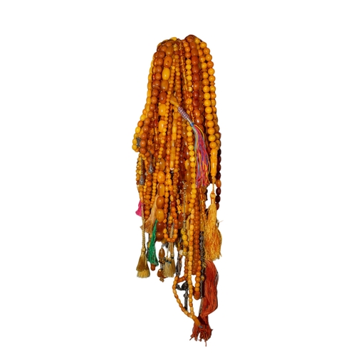 77 - A group of thirty two butterscotch amber, amber and reconstituted amber prayer bead necklacesPropert... 