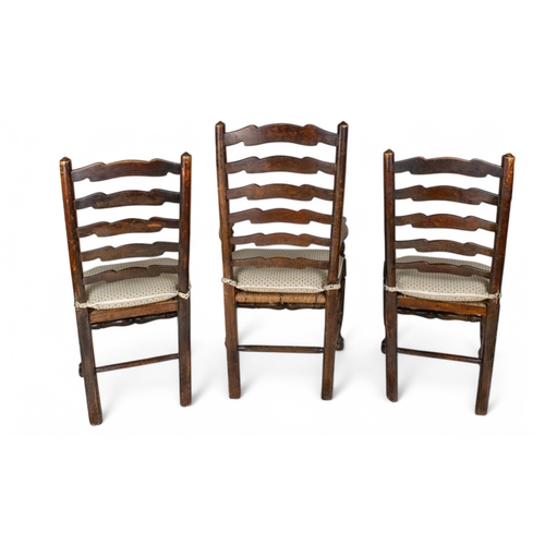 282 - AntiqueA set of six ladder back dining chairs including two carvers, all with rush seatsTo be sold w... 