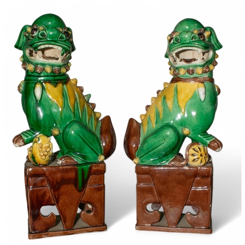 709 - Chineselate 19th century, Qing DynastyA pair of sancai-glazed Foo Dogs, one with a ball, one with a ... 