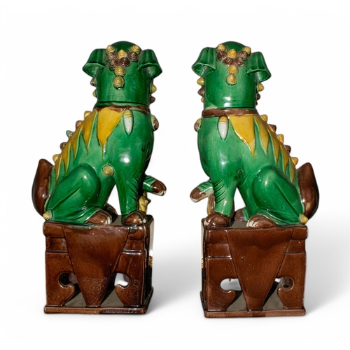 709 - Chineselate 19th century, Qing DynastyA pair of sancai-glazed Foo Dogs, one with a ball, one with a ... 