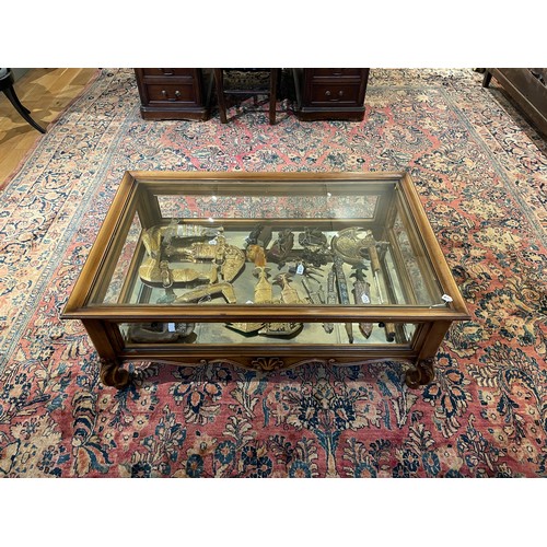 218 - A carved wood and glass low display cabinetWith shell and acanthus leaf design, and a door to either... 