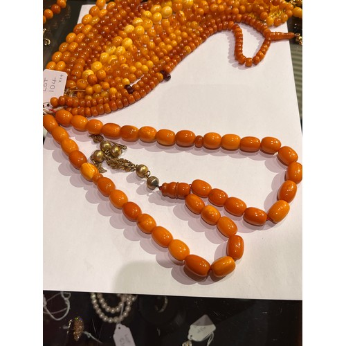 104 - A group of fourteen butterscotch amber and amber prayer bead necklaces. Some with gold and gilt meta... 