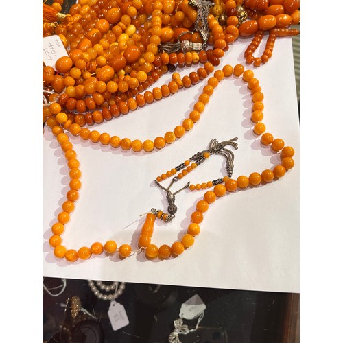 104 - A group of fourteen butterscotch amber and amber prayer bead necklaces. Some with gold and gilt meta... 