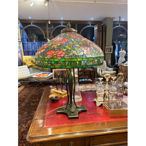 265 - A large Tiffany style stained glass lampWith floral design and four lion paw feetProperty of a noble... 