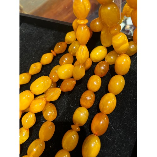 91 - A group of three butterscotch amber prayer bead necklacesProperty of a noblemanTotal weight: Approx.... 