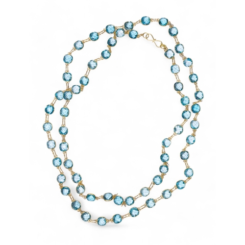 83 - ContemporaryAn attractive blue topaz and 14k gold long chain. The chain collet set with sixty-two br... 