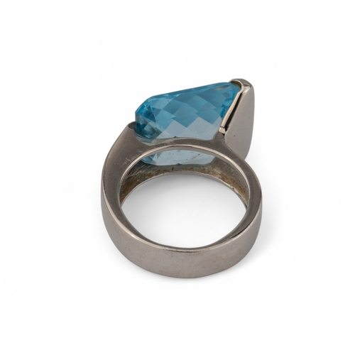 33 - An 18k white gold and blue topaz dress ringThe cushion-shaped briolette-cut topaz within a plain wra... 