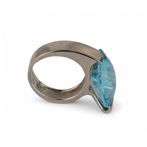 33 - An 18k white gold and blue topaz dress ringThe cushion-shaped briolette-cut topaz within a plain wra... 