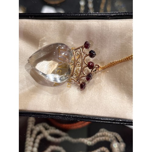 59 - Antique, A heart-shoved rock crystal, gold and garnet pendant, circa 1890.The polished rock crystal ... 