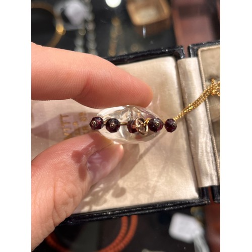 59 - Antique, A heart-shoved rock crystal, gold and garnet pendant, circa 1890.The polished rock crystal ... 