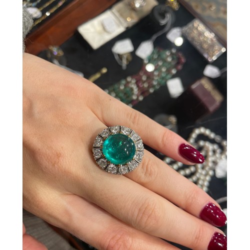 88 - A striking cabochon emerald and diamond cluster ring, circa 1950The central ovoid-shaped cabochon em... 