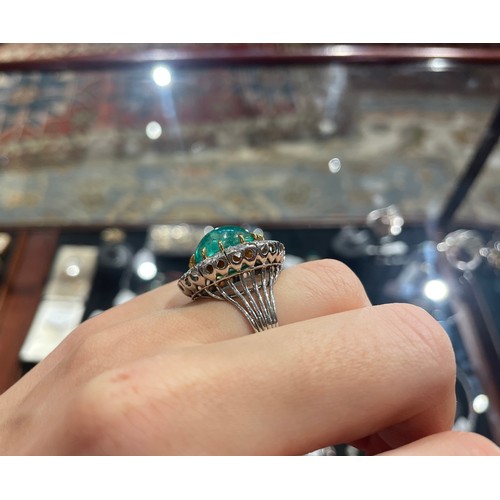 88 - A striking cabochon emerald and diamond cluster ring, circa 1950The central ovoid-shaped cabochon em... 